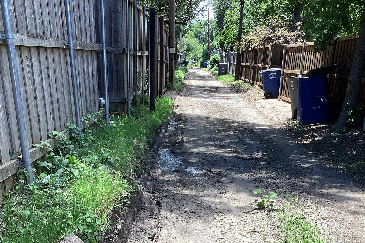 Narrow alley with limited clearance for a collection truck and crew.